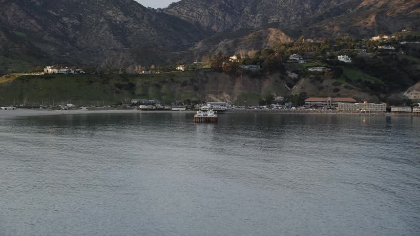 Aerial approach to the Malibu pier with mountains in the background