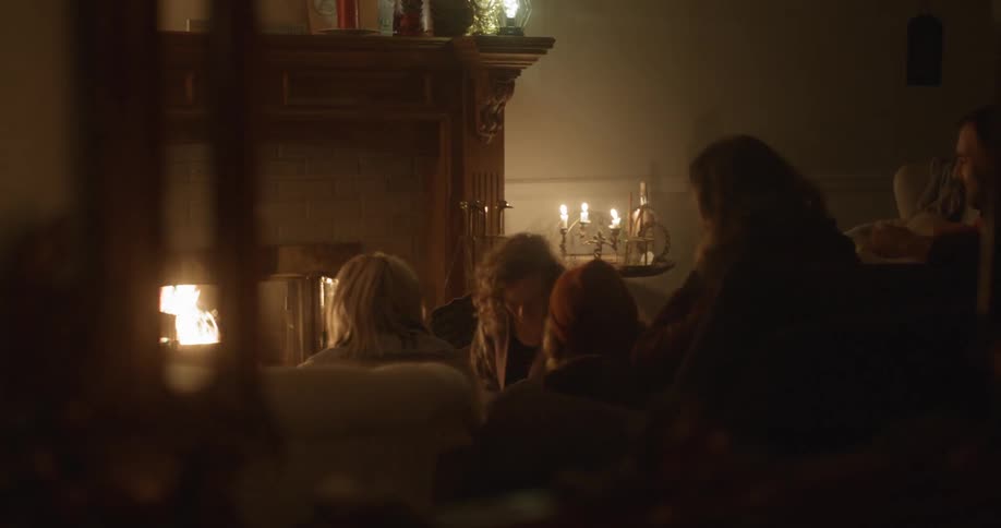 A family talks in front of the fire chimney on the night