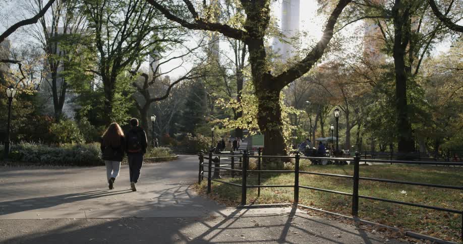 A couple walks through the park