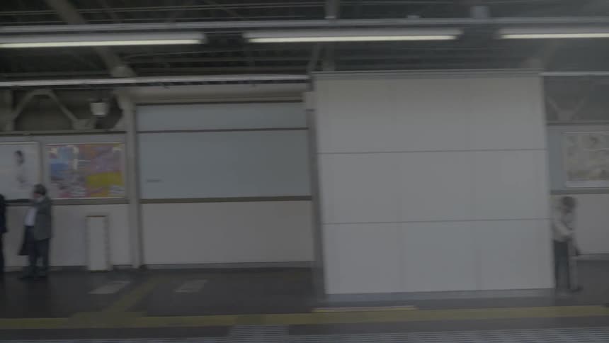 Passengers wait at a train station