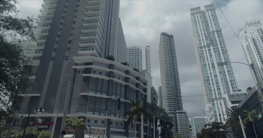 Riding along street between tall white color skyscrapers