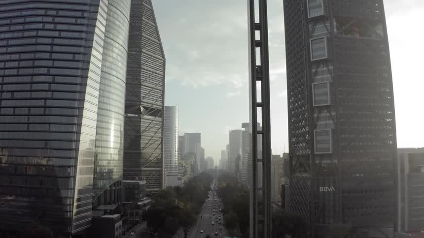 Vehicles travel the roadway through a large city