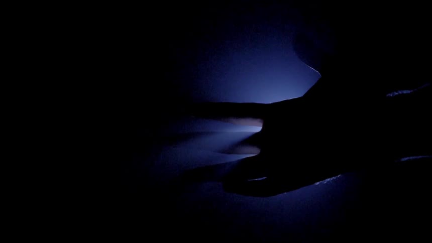 A hand blocks light from a projector