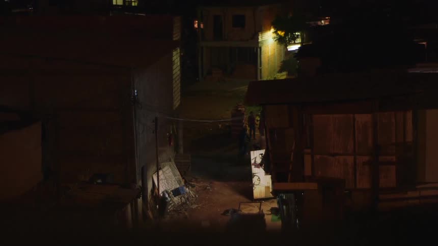 People walking through a dark alley at night
