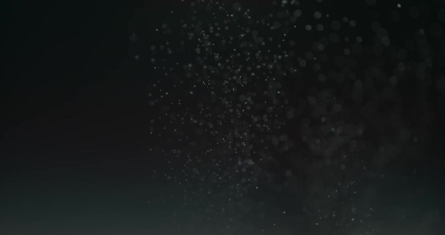 Small air bubbles rising up on a clear liquid in a dark enviroment
