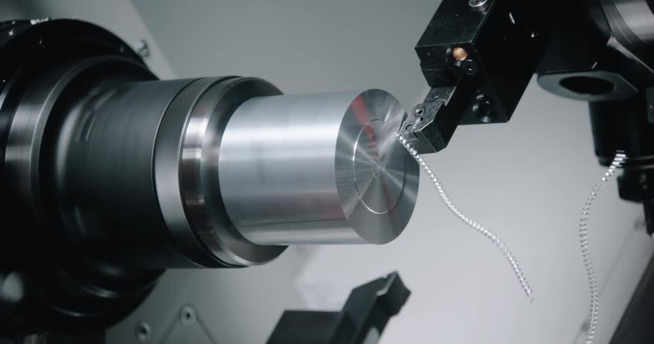 A machine shaves a metal cylinder