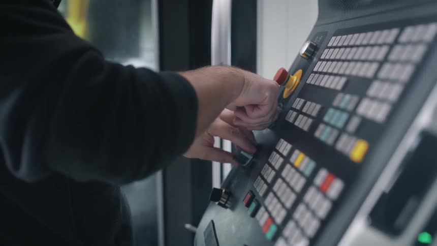 Man turns dials on machine interface
