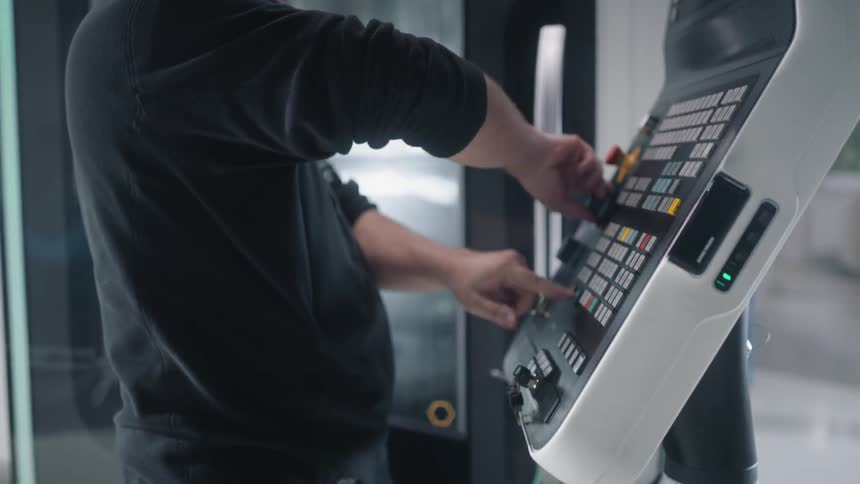A man turns a knob on a large electronic device