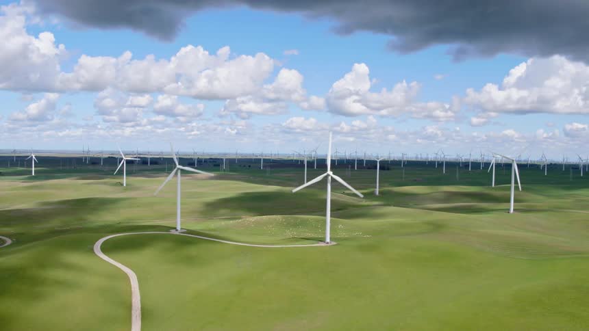 Windmills turn on a wind farm under cloudy skies