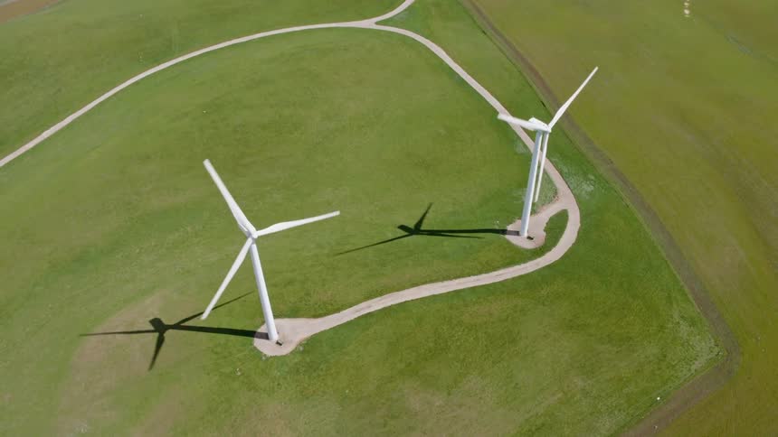 The windmills spin on the field below