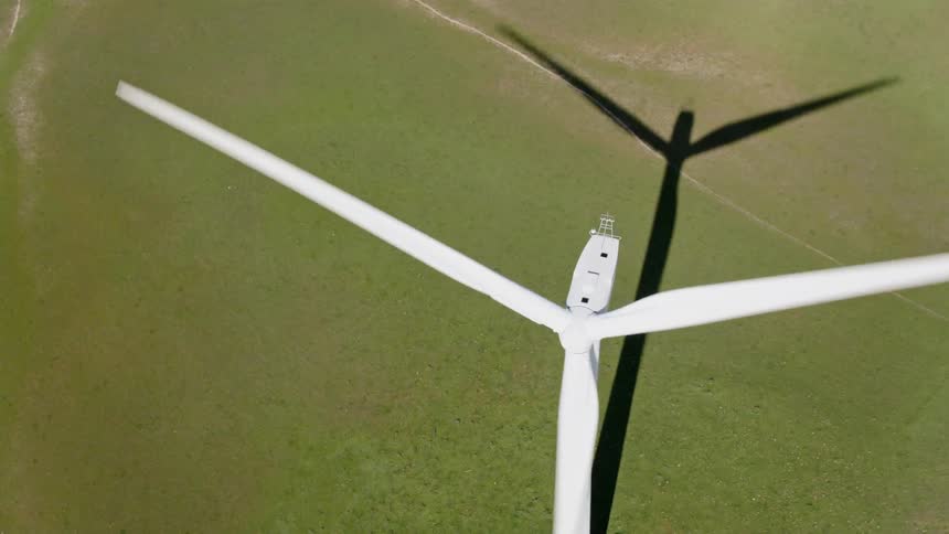 A windmill is moving in a grassland area