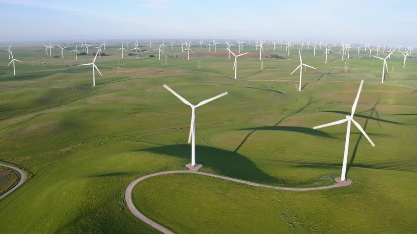 An aerial view of wind turbines in a rural field