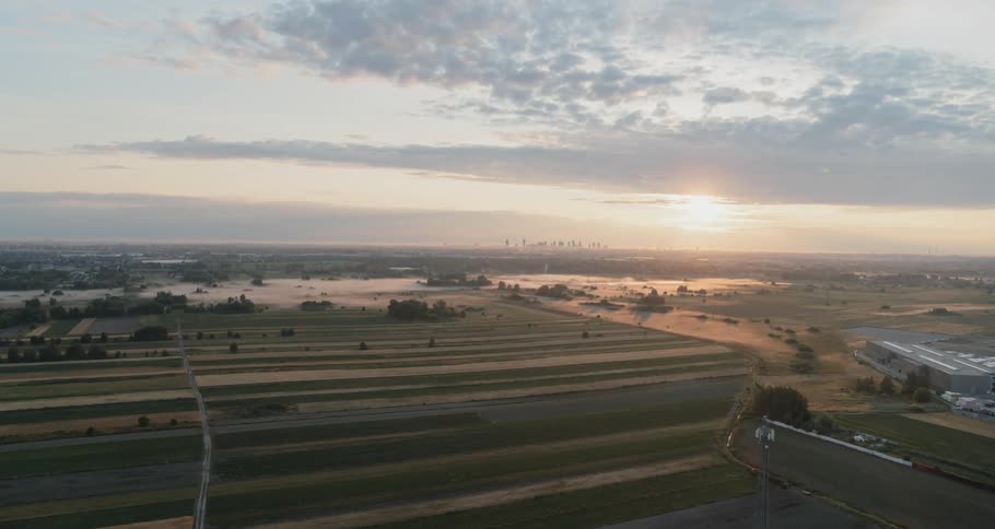 A large farmstead at dawn under cloudy skies