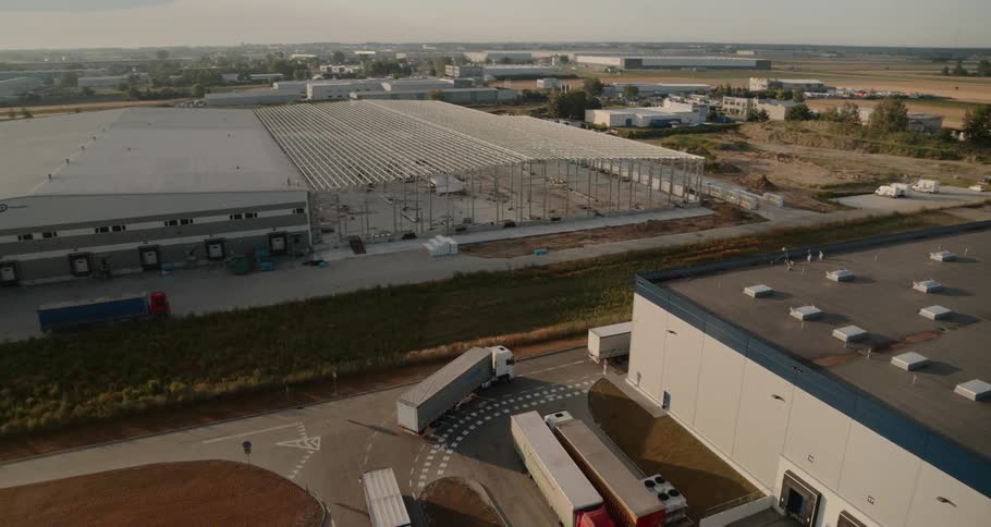 A line of semi trucks leave plant area