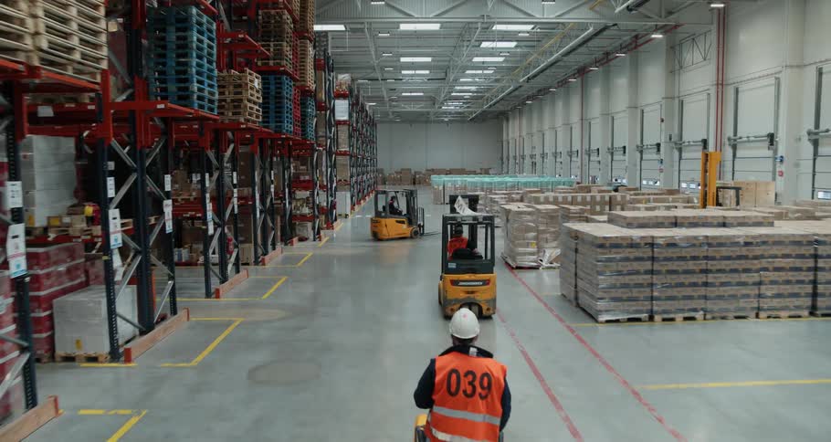 Workers are moving pallets around with fork lifts