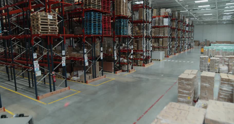 Forklift operators move boxes through a warehouse full of shelves