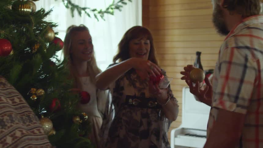 People talking, laughing and decorating a christmas tree