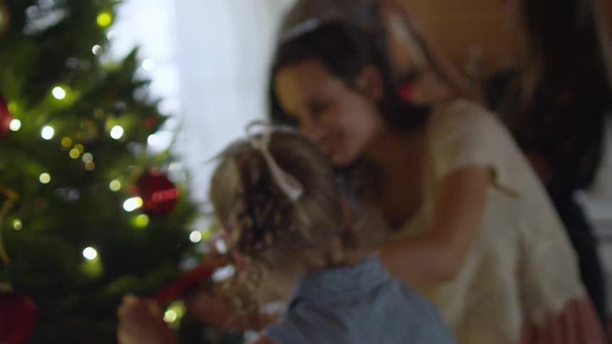 A woman and girl decorating a christmas tree