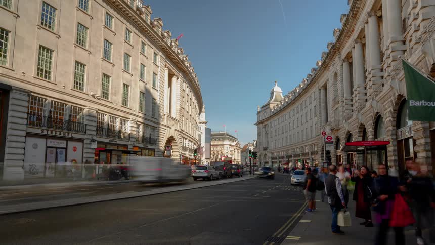 A busy street with people and vehicles and buildings in the background