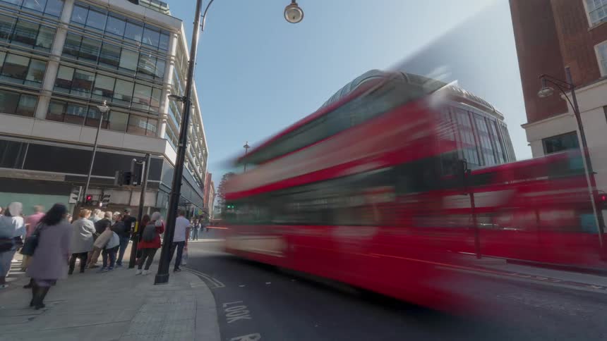 Countless pedestrians and vehicles pass by during a time lapse of this busy city intersection