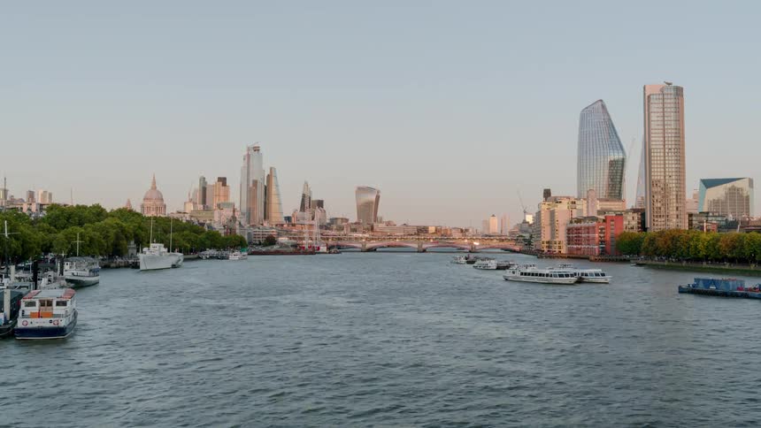 A rivers flows along the banks of a large city and serves as a passageway for a number of watercraft