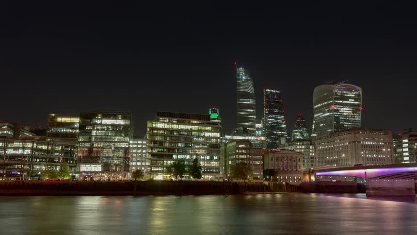Traffic travels on the bridge over the river in the city at night