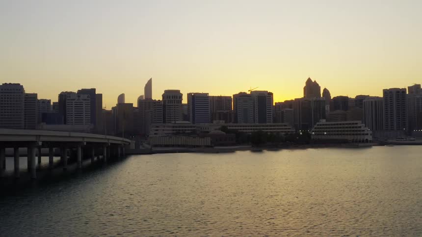 Skyline of the city with tall buildings and skyscrapers next to river at dawn