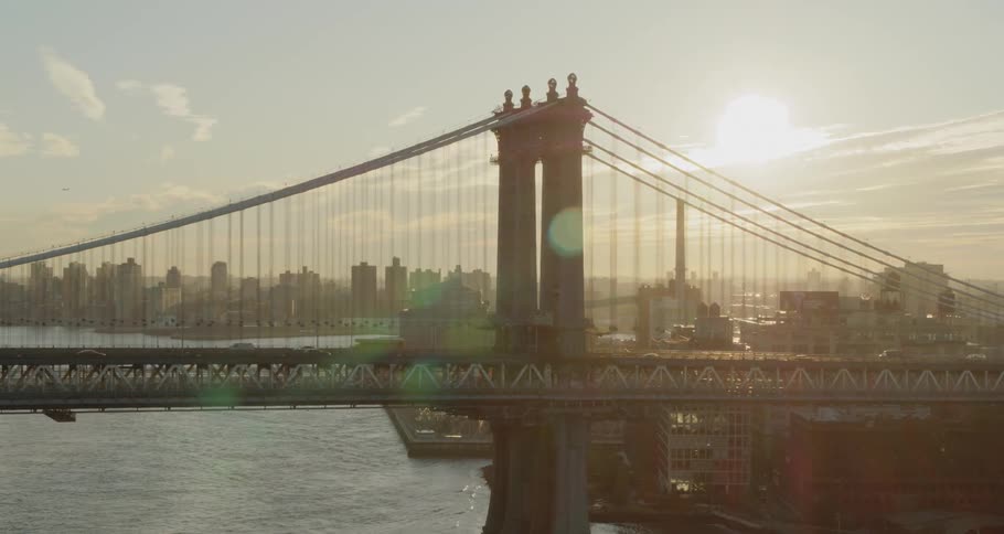 The vehicles travel over the bridge at sunrise