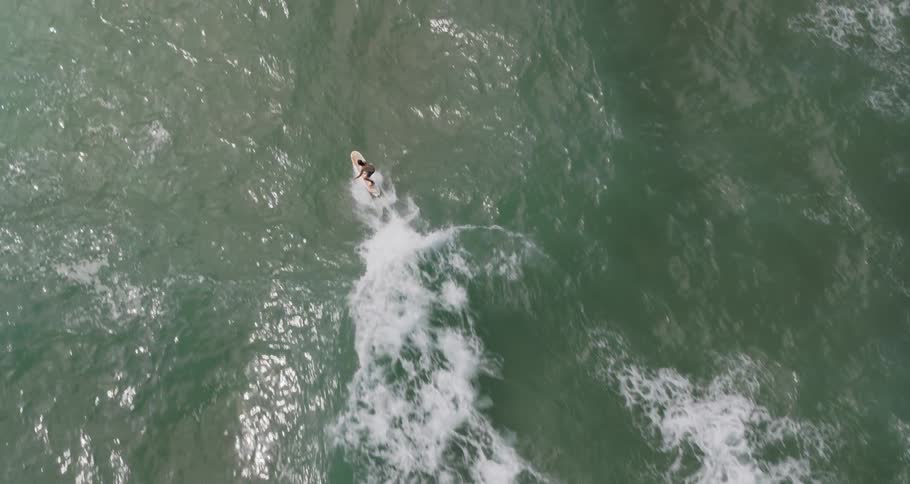 The person is riding the surfboard below