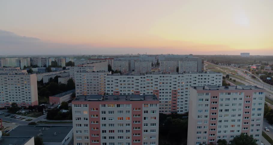 White and pink apartment buildings sit next to a highway