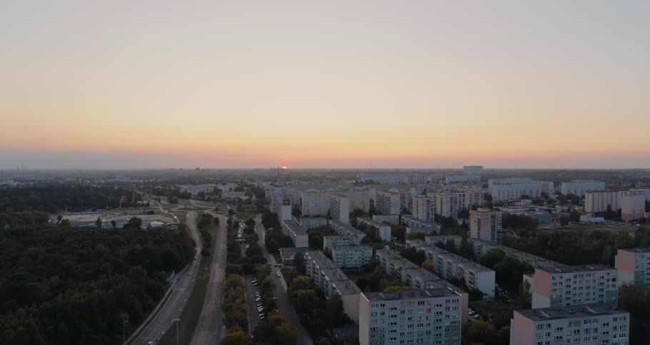 A highway running through an urban area is visible in the dawning light