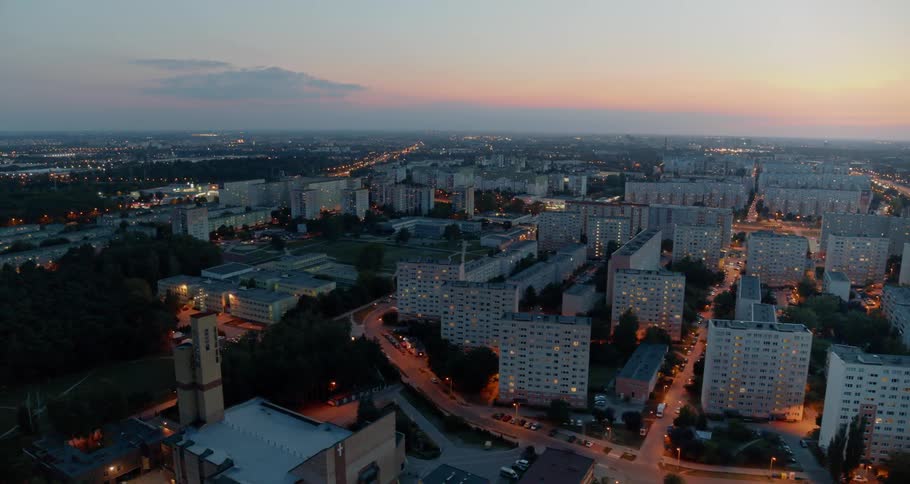 An urban area with several high rise buildings is visible as the sun sets