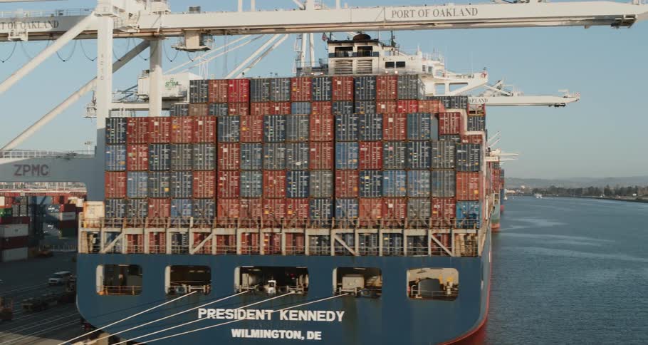 Several cargo ships loaded with shipping containers are docked for unloading