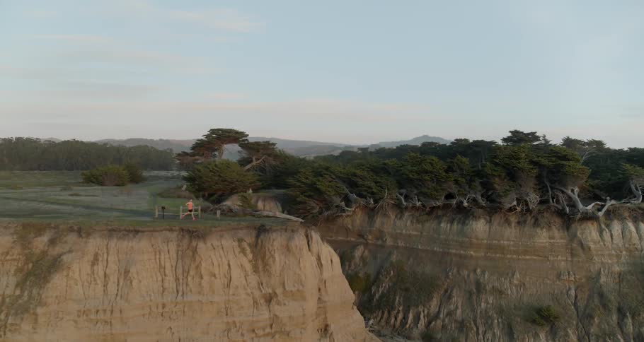 A runner jogs along a cliff line