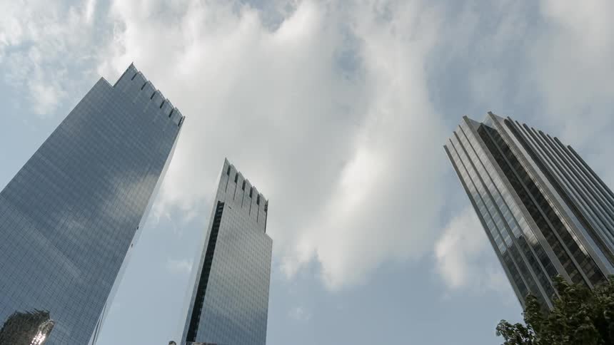 Clouds move over tall buildings in a city