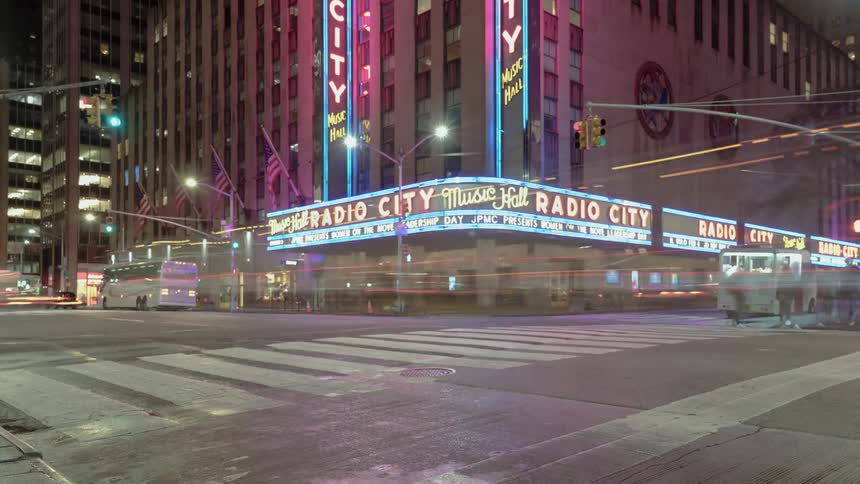 Traffic travels in the city as bicyclists and pedestrians move nearby