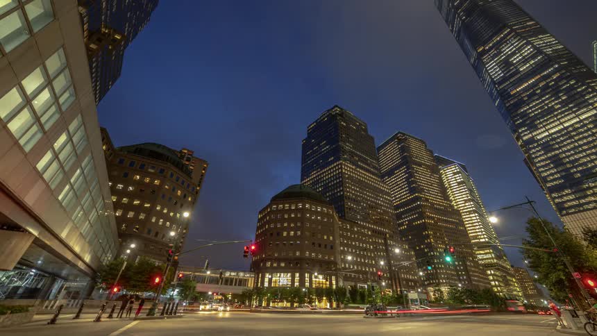 Traffic and people move through a downtown intersection at night