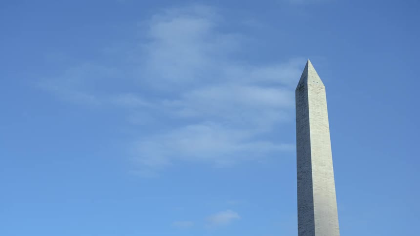 Clouds blowing past a monument