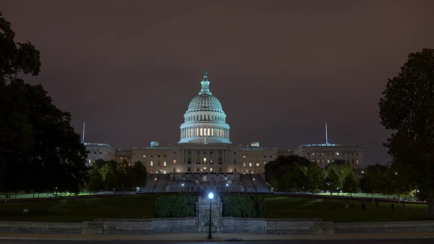 Clouds float above the us capitol building at night