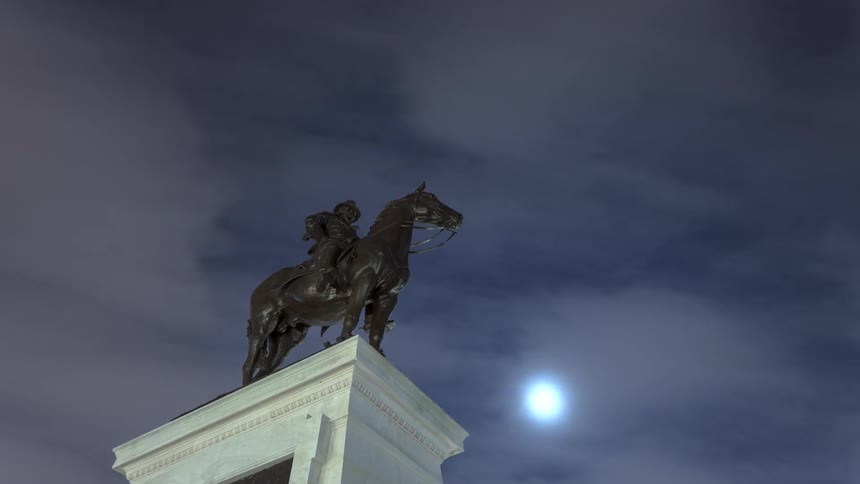 Time lapse of equestrian statue on park at night at full moon