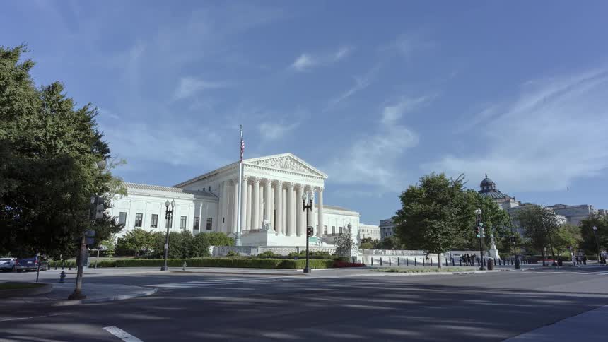 Traffic passes along avenue in front of supreme court building