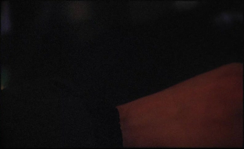 A person wearing a jacket resting their hand on a desk