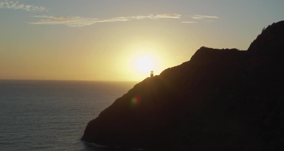 A lighthouse on the cliff of a mountain during sunrise