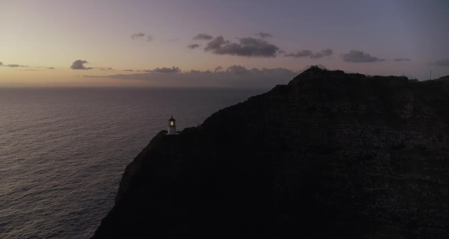 A lighthouse on a hill overlooking the water