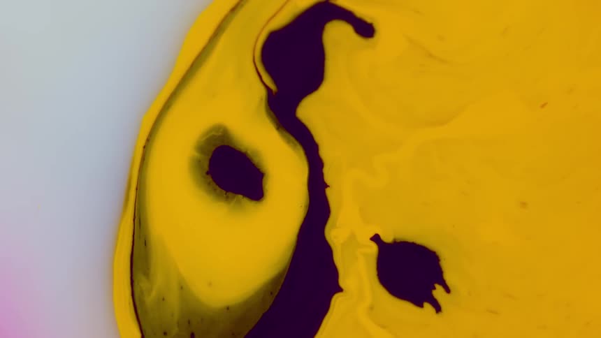 A yellow liquid contracting on a white surface