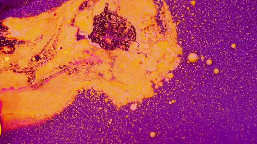 Globs of liquid float in a purple substance