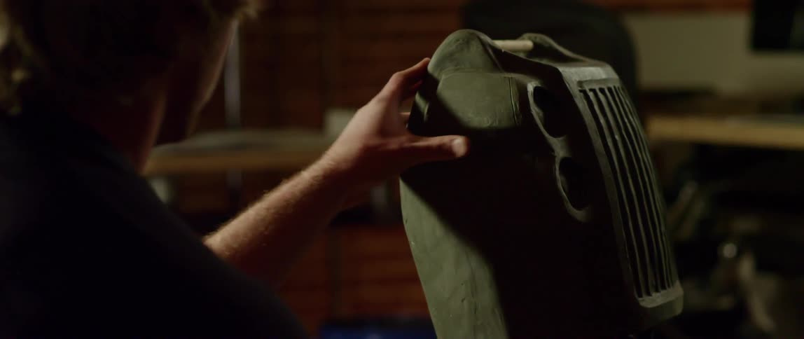 A man massage a wet clay sculpture with one hand