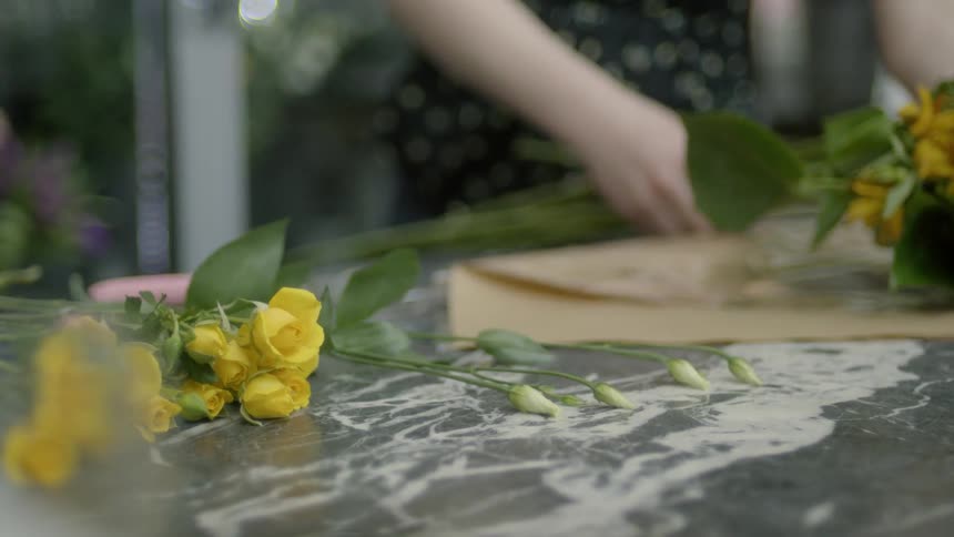 A florist is bundling flowers together