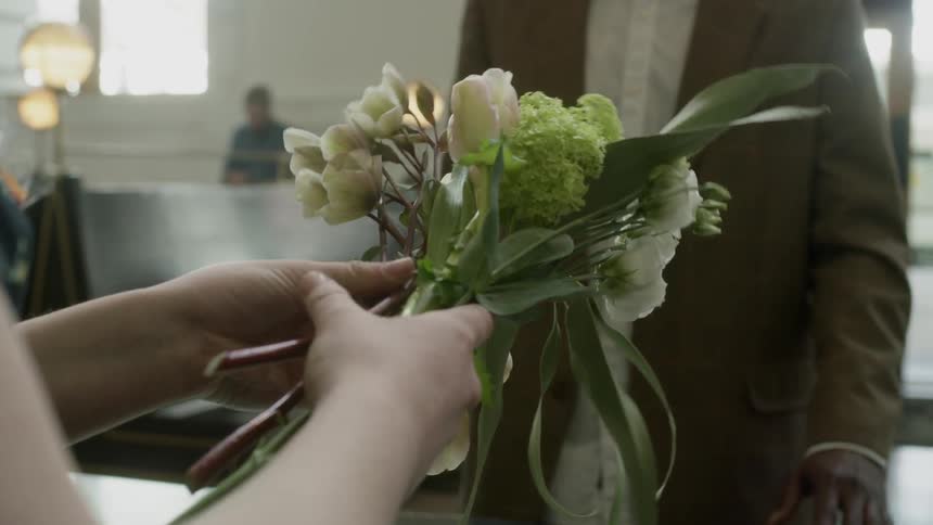 A customer is buying flowers in a shop