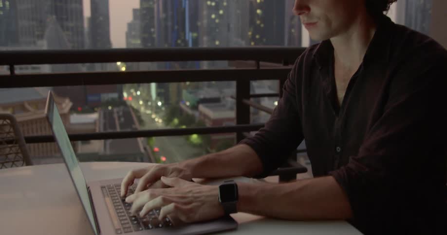 A man types on his laptop
